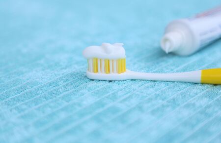 white tooth paste on the yellow tooth brush