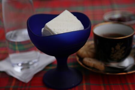 Ice cream in blue glass cup, coffee cup and clean water glass on the table