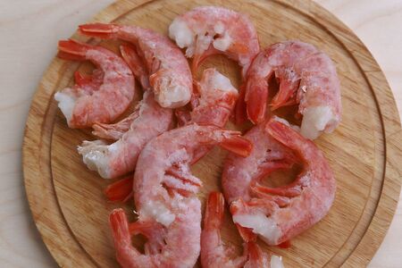 Several pieces of shrimp frozen before cooking thaw on a round boardの写真素材