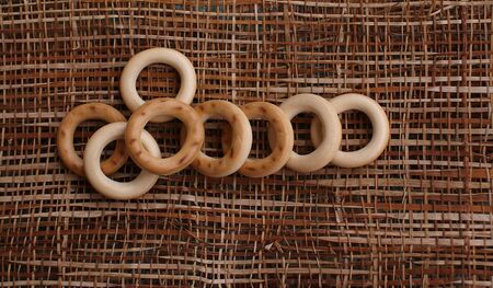 Little bread rings on the straw on the table view from above