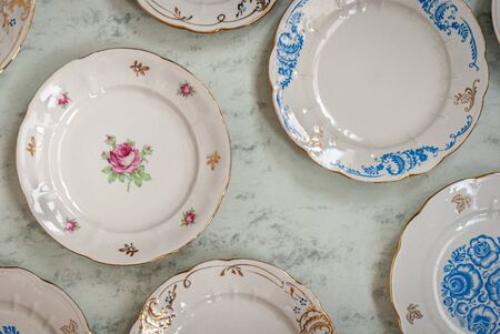Some old fashioned ceramic  grandmother's plates with flowers and tracery on a marbel table flatlyの写真素材