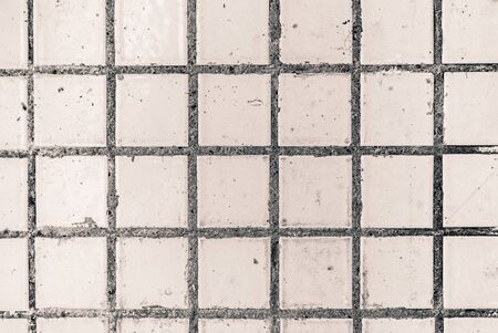 Old white small square dirty tile wallの写真素材