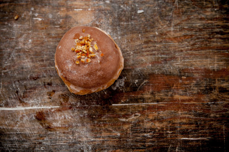 Donut with chocolate glaze on wooden background. Toned.の写真素材