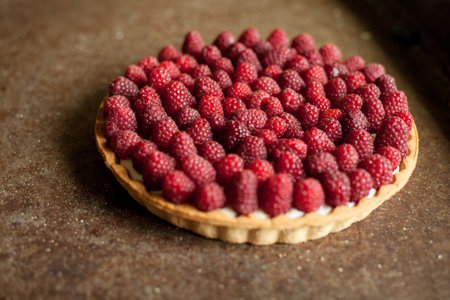 Raspberry tartlet on a rustic background. Toned.