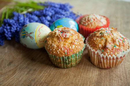Easter muffins with colored eggs and muscari flowers on wooden backgroundの写真素材