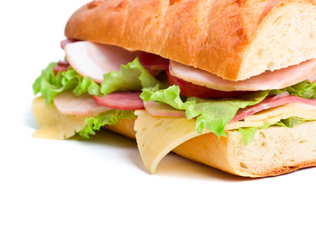 half of long baguette sandwich with lettuce, tomatoes, ham, turkey breast and cheeseの写真素材