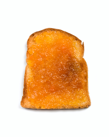 crispy white bread toast with orange jam spread isolated on white backgroundの写真素材