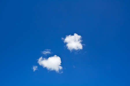 bright blue sky with two small white clouds background