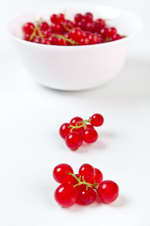bowl of redcurrants with some close up in frontの写真素材