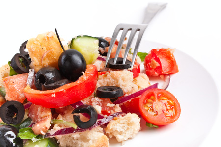 serving of traditional Italian Panzanella Bread salad on a white plate with a fork on white backgroundの写真素材