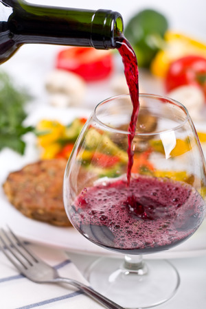 red wine poored from a bottleの写真素材