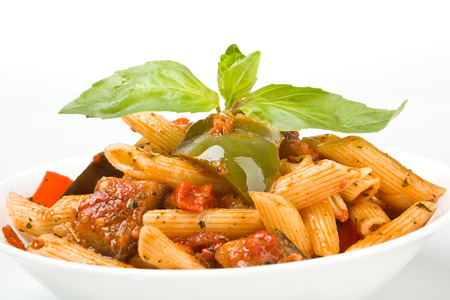 Mediterranean penne pasta in a white bowl with the garnish vegetables in a separate bowlの写真素材
