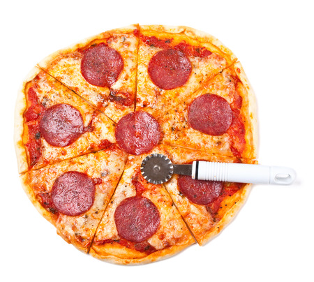 sliced salami pizza with a pizza-knifeの写真素材