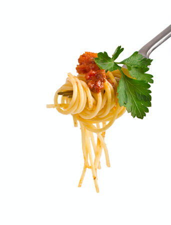 spaghetti with sauce bolognese and green parsley hanging on a forkの写真素材