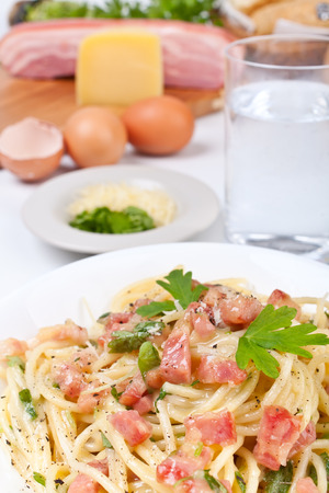 serving of spaghetti carbonara with ingredientsの写真素材