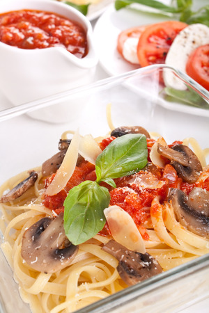 bowl of pasta linguine with mushrooms, tomato sauce and parmesan cheeseの写真素材