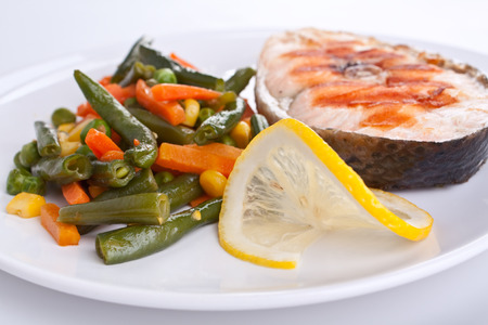 salmon steak with green beans on white plateの写真素材