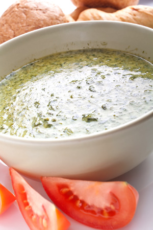 spinach cream soup with bread and tomatoesの写真素材
