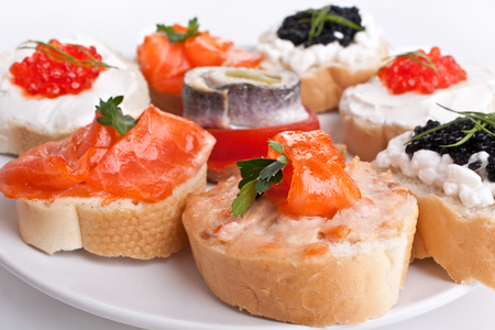 group of small sandwiches with red and black caviar, herring  and salmonの写真素材