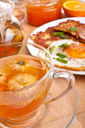tea with classic eggs, hash browns and bacon breakfastの写真素材
