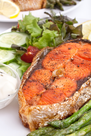 grilled salmon with vegetables, asparagus, lemon and cream sauceの写真素材
