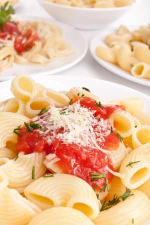 close-up servings of pasta with tomato sauce and grated cheeseの写真素材