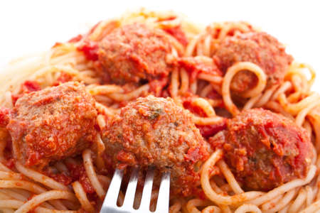 spaghetti with meatballs in tomato sauce and a forkの写真素材