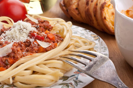plate of spaghetti bolognese with parmesan cheese and a forkの写真素材