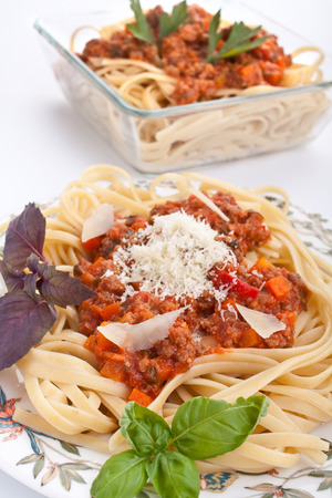 two servings of spaghetti bolognese with parmesan cheese and basilの写真素材