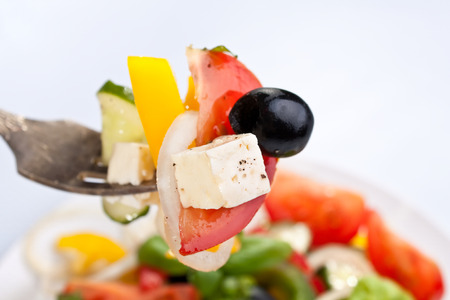 healthy greek salad on a forkの写真素材