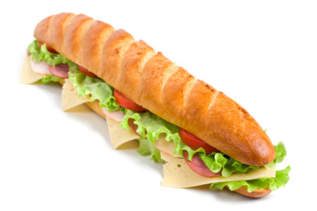 long baguette sandwich with lettuce, slices of fresh tomatoes, ham, turkey breast and cheeseの写真素材