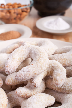 horse-shoe shaped homemade vanilla and almond cookies with ingredients and a mortarの写真素材