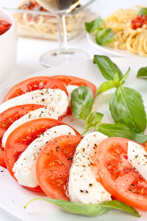 classic caprese salad and pasta with tomato sauceの写真素材