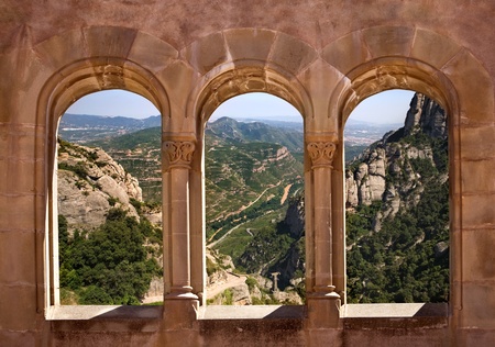 Kind from arch windows of a monastery of Monserrat on a valleyの写真素材