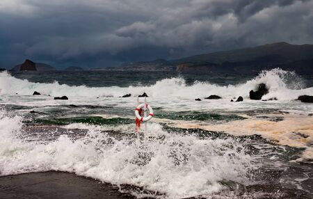 Lifebuoy against a raging seaの写真素材