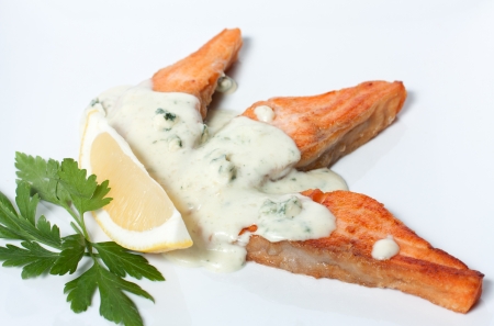 Slices of fried red fish with white sauceの写真素材