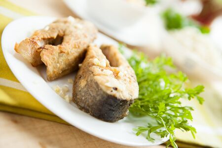 Fried fish on a white plate, close upの写真素材