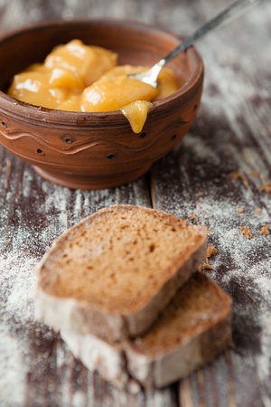 Buckwheat honey in a ceramic bowl and brown bread, foodの写真素材