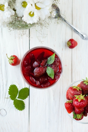 strawberry jam in a bowl on a white table