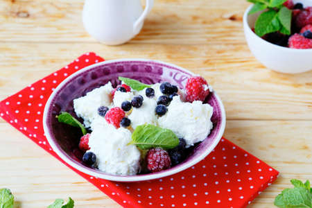 cottage cheese with fresh raspberries and blueberries, food closeupの写真素材