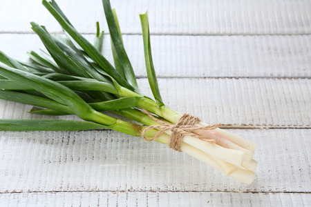 bunch of green garlic on white boards, food closeupの写真素材