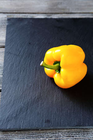 yellow pepper on slate background, food closeupの写真素材