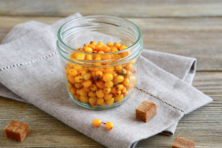 Sea-buckthorn in a glass jar on linen napkin, healthy foodの写真素材