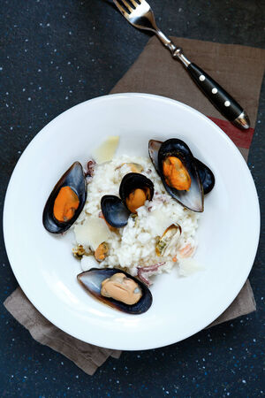Italian mussels with rice in white plate, top viewの写真素材