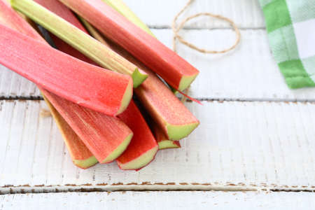 Fresh rhubarb on wooden boards, white backgroundの写真素材