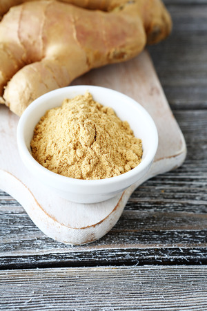 Fresh ginger root with powder on a cutting board, spicyの写真素材