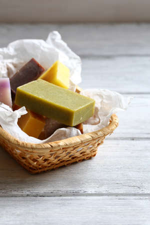 Handmade soap in a wicker basket, wooden backgroundの写真素材