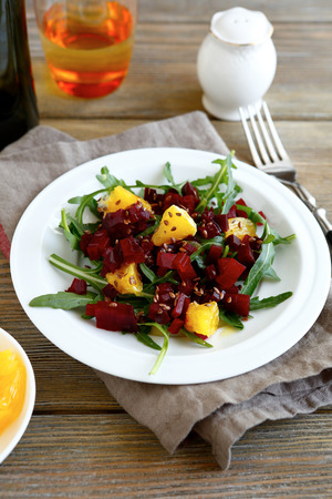 Salad with beet, arugula and orange on a white plateの写真素材