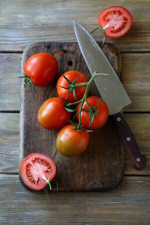 tomatoes on the old cutting board, food top viewの写真素材