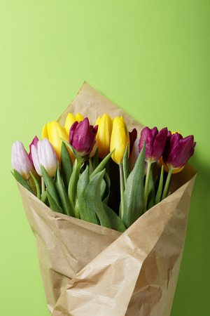 spring tulips wrapped in craft paper on green background, flowersの写真素材